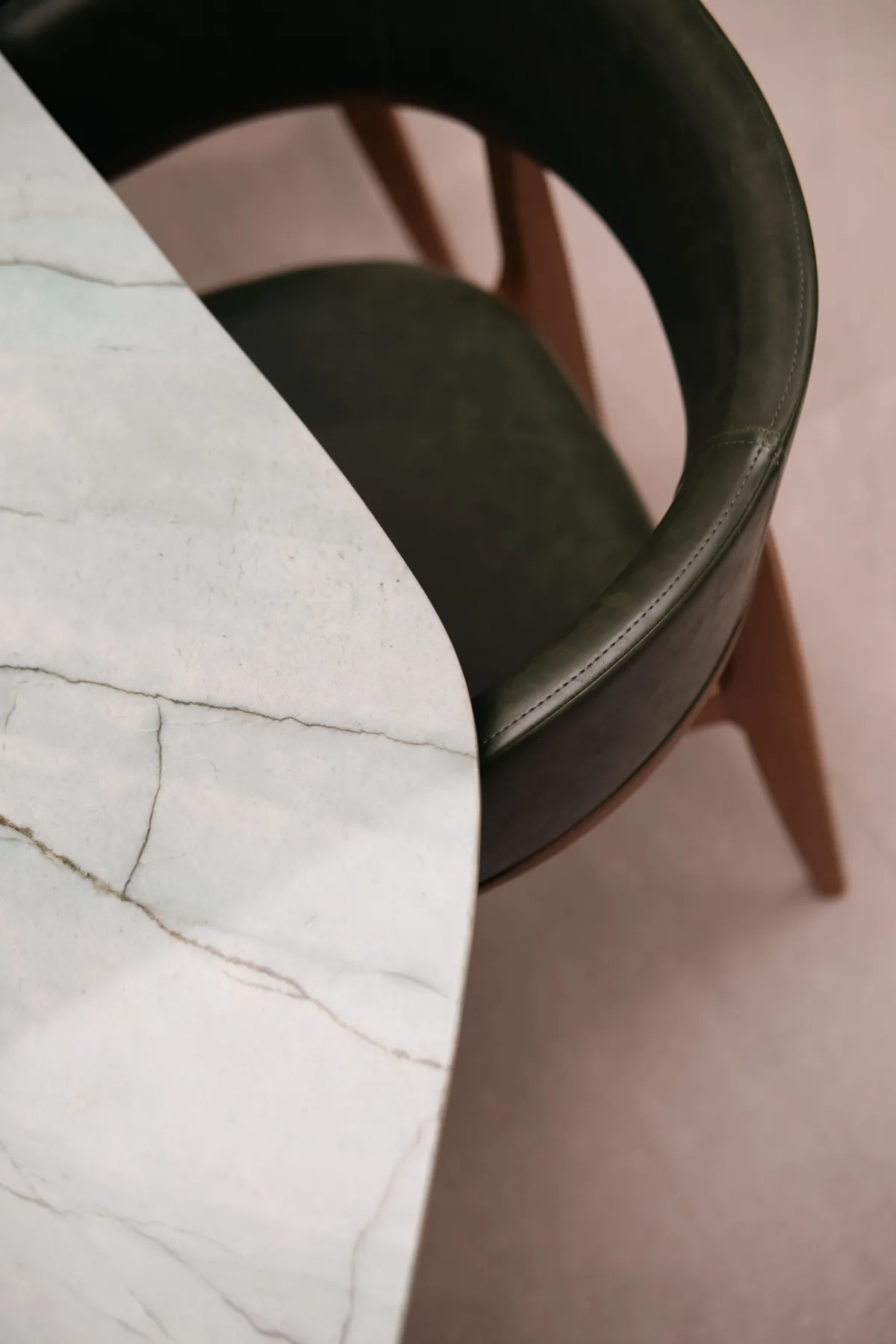 Detalhe do consultório com mesa e cadeira em mármore e madeira, iluminação intimista