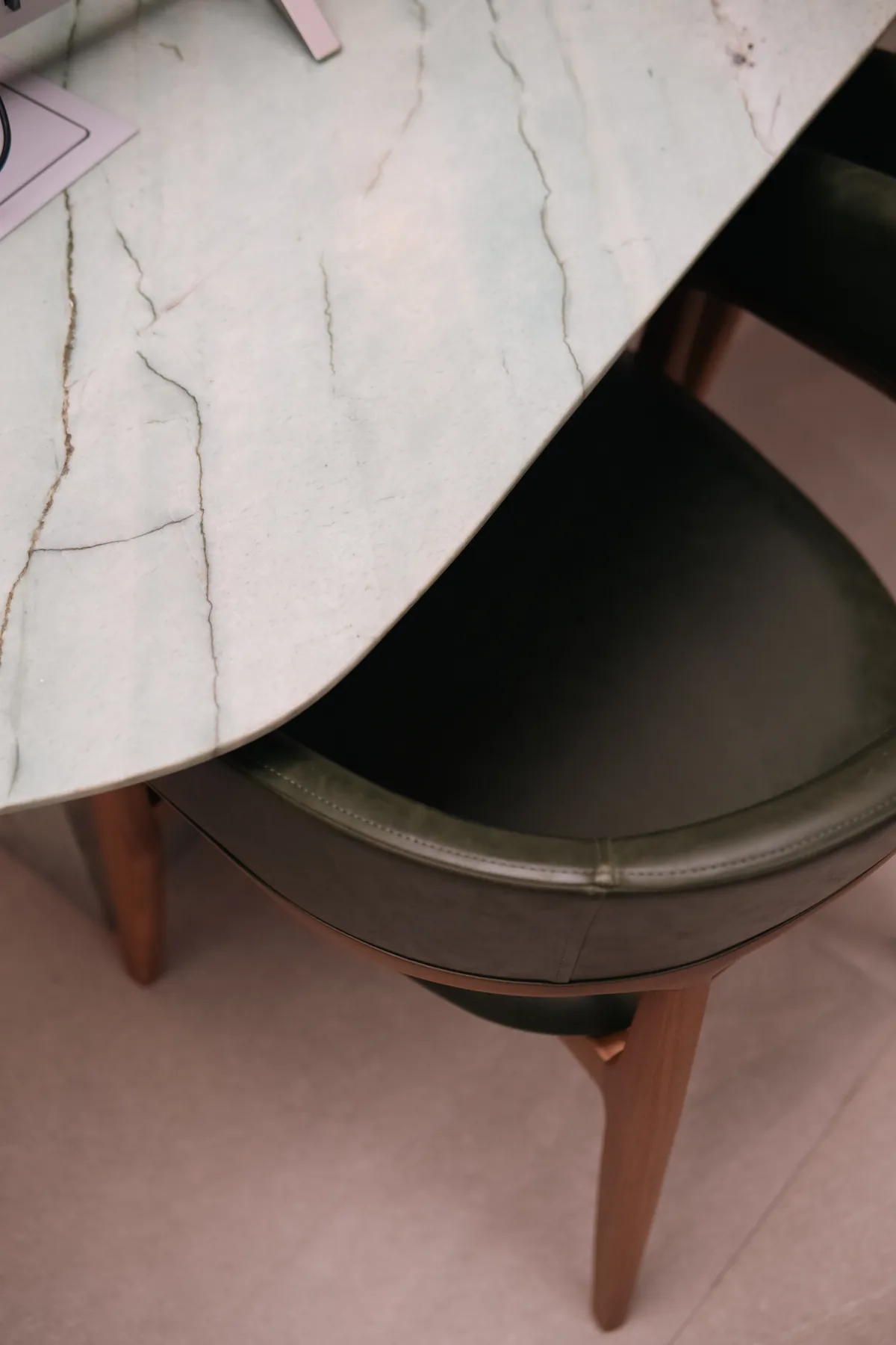 Sala de reunião do Instituto Bonica em Brasília com mesa oval de mármore branco e cadeiras em couro verde escuro